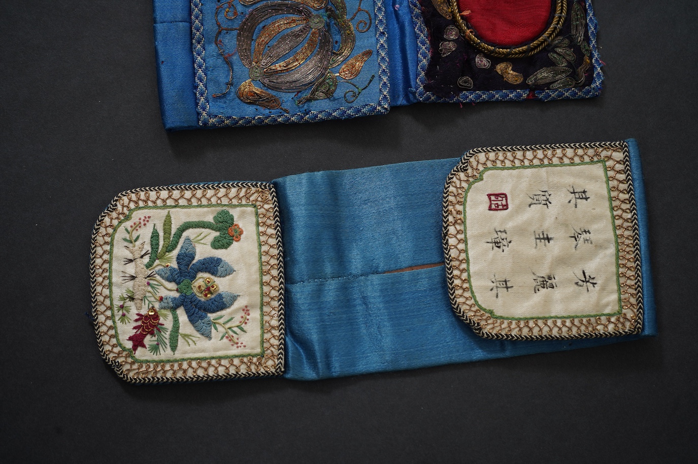 Two Chinese late Qing Dynesty coloured silk and gold thread embroidered belt purses, or ‘hebao’, for carrying coins, seals and fragrant herbs etc. One - 19cm long,in cream silk, with the embroidered words: “It’s music is